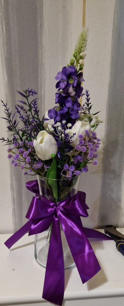 Purple Wishes - An elegant artificial vase arrangement in purple and white, finished with a beautiful satin bow.