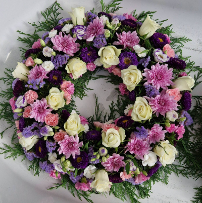 Precious Memories - A full and elegant funeral wreath in soft pink, purple and cream tones, created as a heartfelt tribute to a loved one.